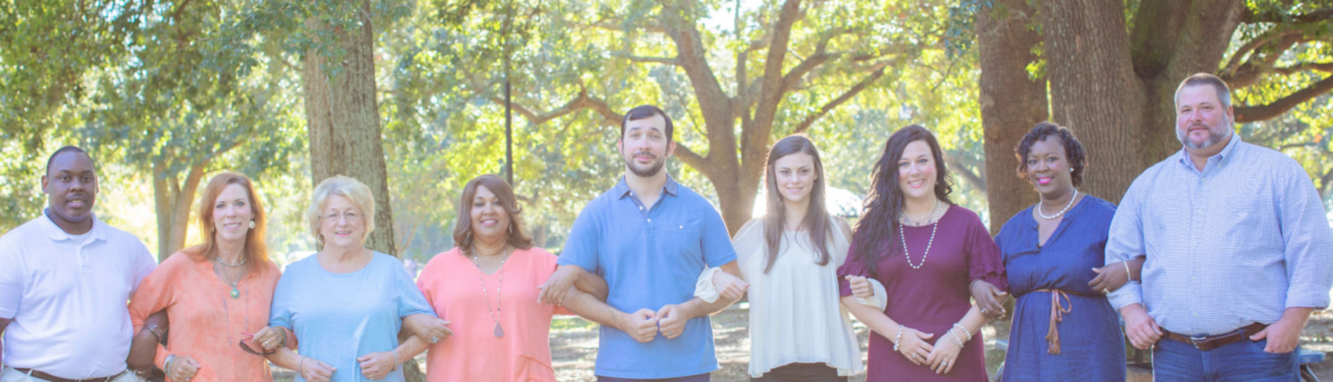 group of people standing arm-in-arm