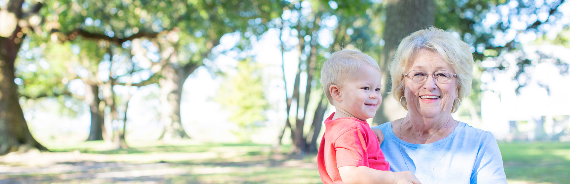 Older woman holding a child smiling