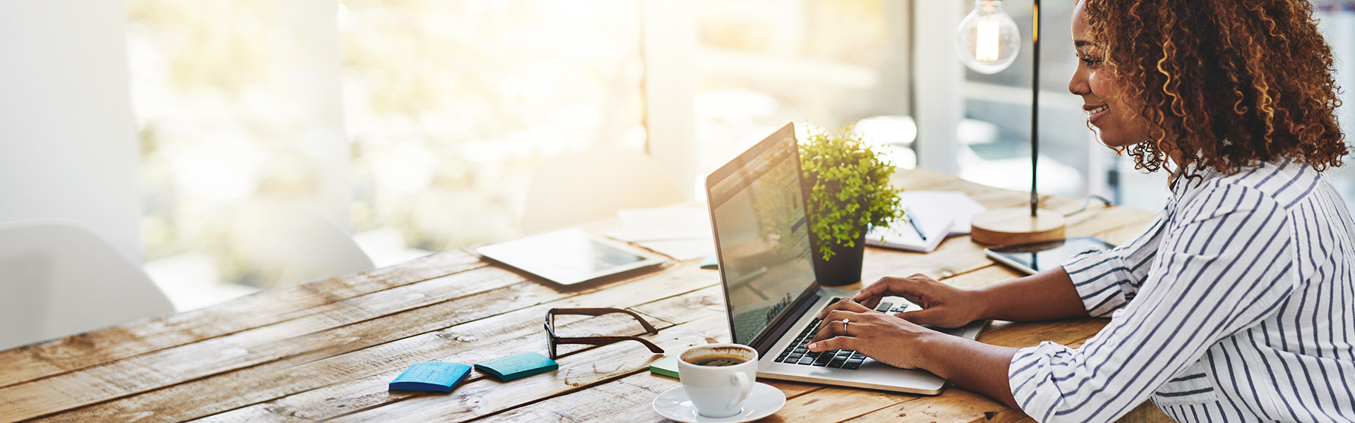 Woman sitting at table typing on laptop